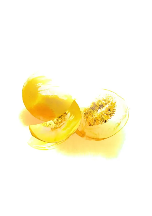 Yellow melon with one sliced open showing inner seeds