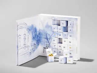 White advent calendar with numbered drawers and winter landscape drawing