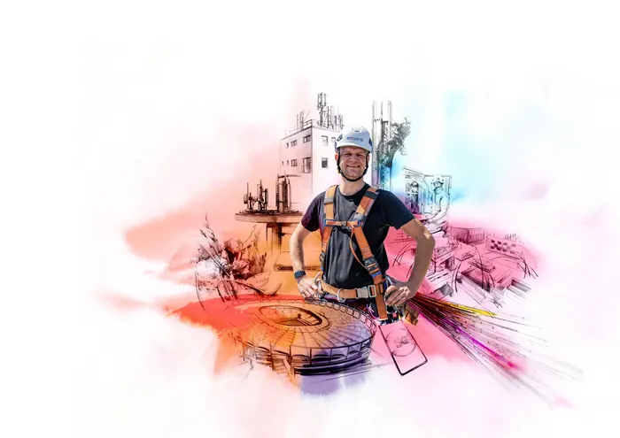 Engineer in harness and helmet at construction site with blueprints