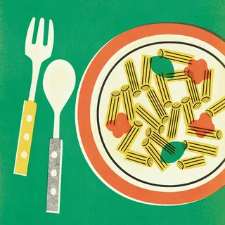 Plate of pasta with sauce and fork and spoon on green background