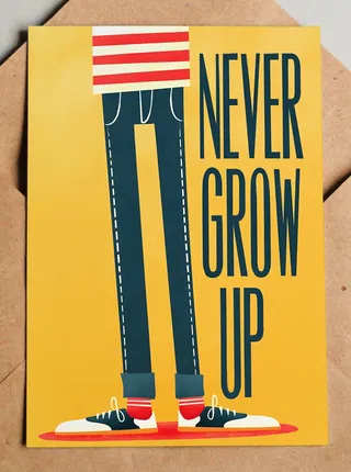 Legs wearing sneakers with 'Never Grow Up' message on yellow background
