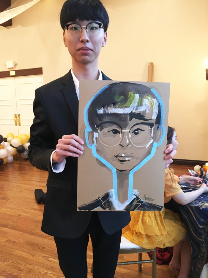 Live event drawing of a boy with glasses
