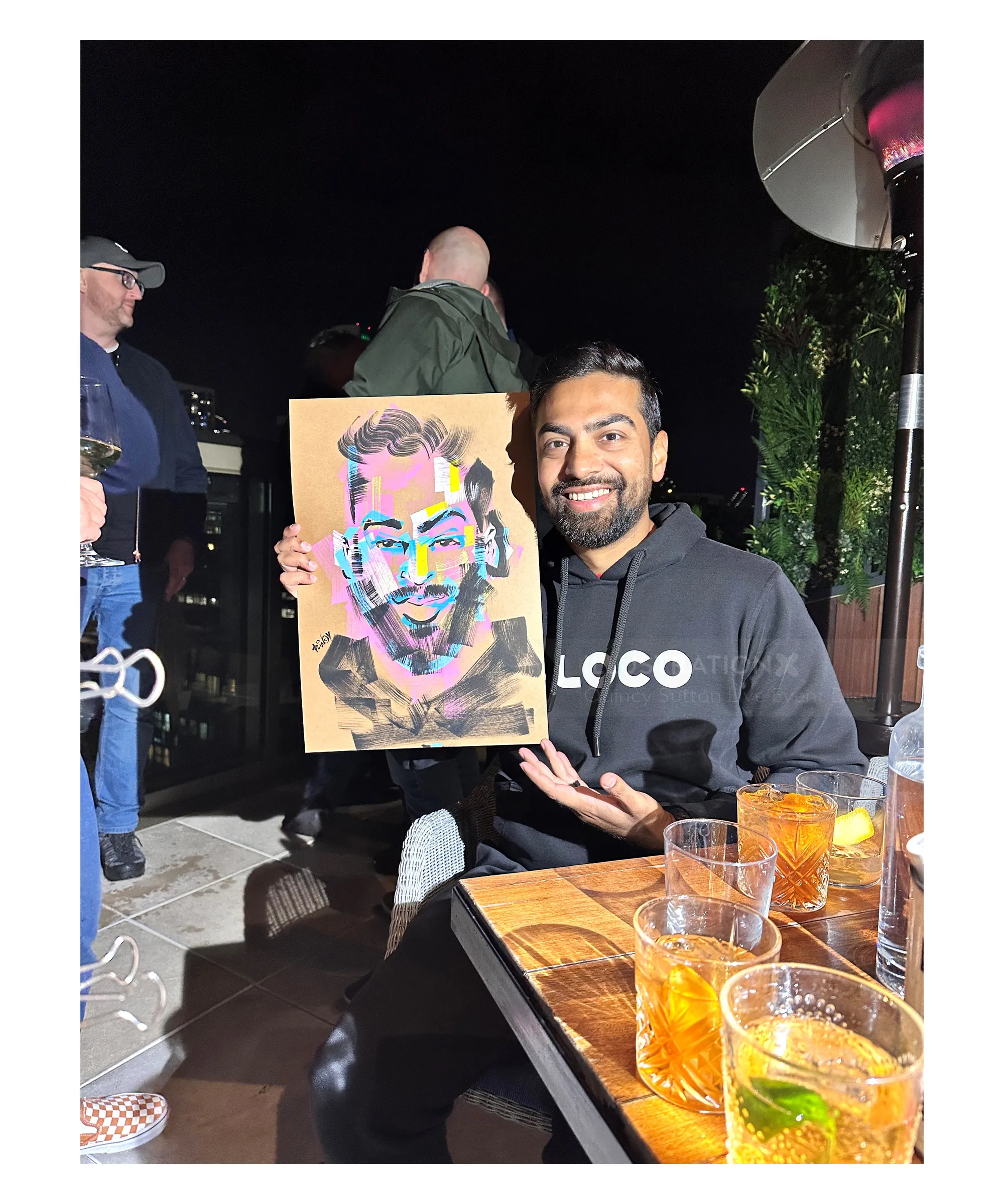 Man showing colorful pop art portrait at night by Quincy Sutton