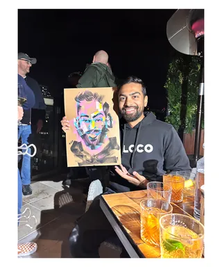 Man showing colorful pop art portrait at night by Quincy Sutton