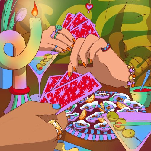 Hands holding red cards playing a game with drinks and candles