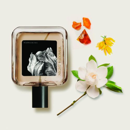 Perfume bottle labeled Night Bloom with white and yellow flowers by Reiko Lauper