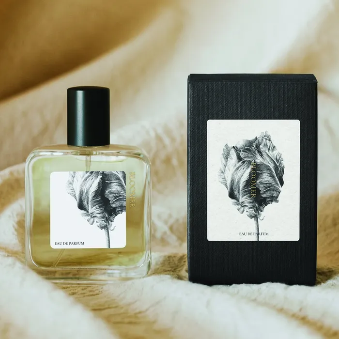 Perfume bottle and black box with black feather artwork by Reiko Lauper
