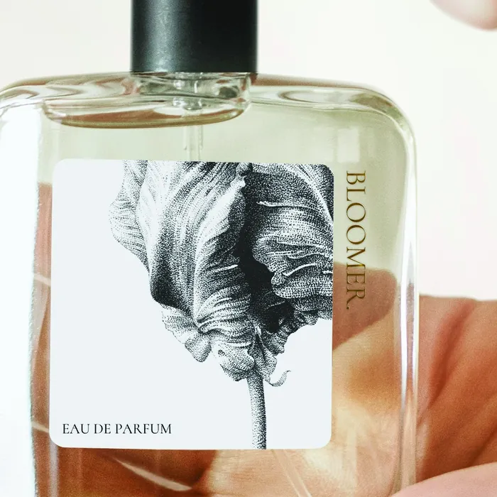 Glass perfume bottle with Bloom Eau de Parfum label and botanical illustration by Reiko Lauper