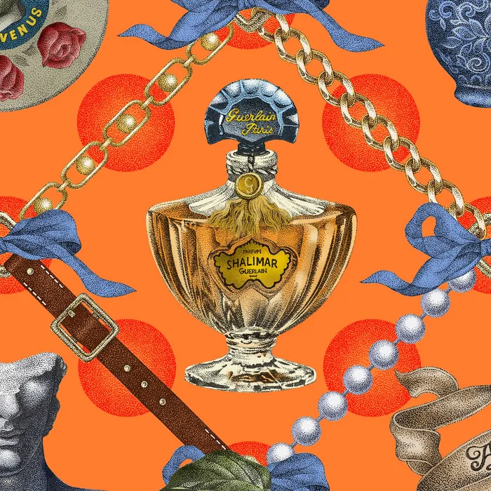 Vintage perfume bottles with jewelry and accessories on orange background