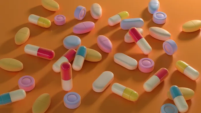 Colorful capsules and pills on orange background, by RIVE GAUCHE