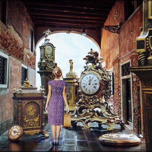 Woman in purple dress looking at antique clocks in a museum, by RIVE GAUCHE