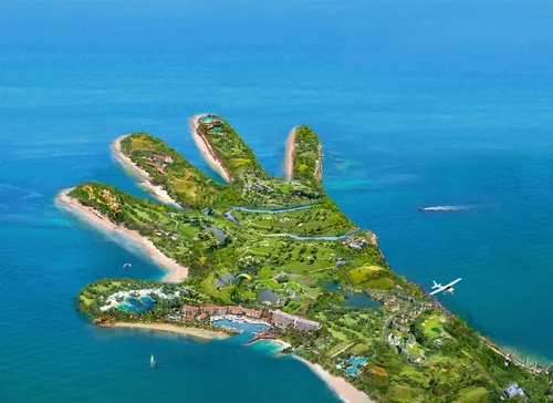 Aerial view of hand-shaped island with greenery and ocean by RIVE GAUCHE