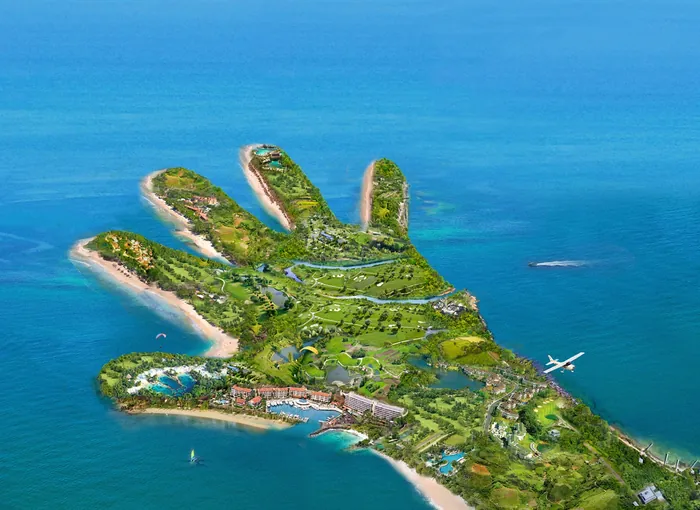 Aerial view of hand-shaped island with greenery and ocean by RIVE GAUCHE