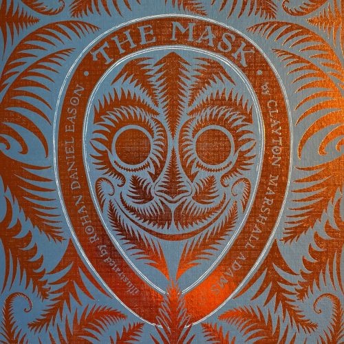 The Mask book cover with ornate orange mask and fern patterns by Rohan Eason