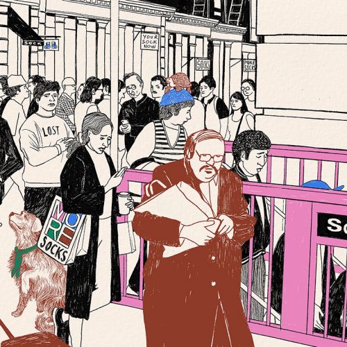 Crowded street scene with people, bus, and sock shop