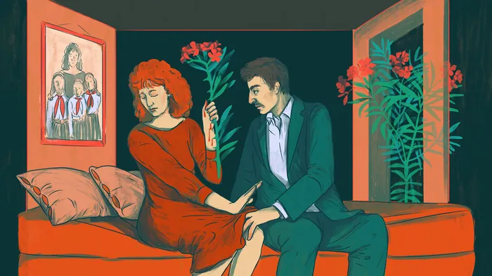 Couple sitting on a couch with the man giving flowers to the woman
