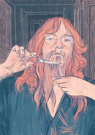 Person with long red hair cutting beard with scissors