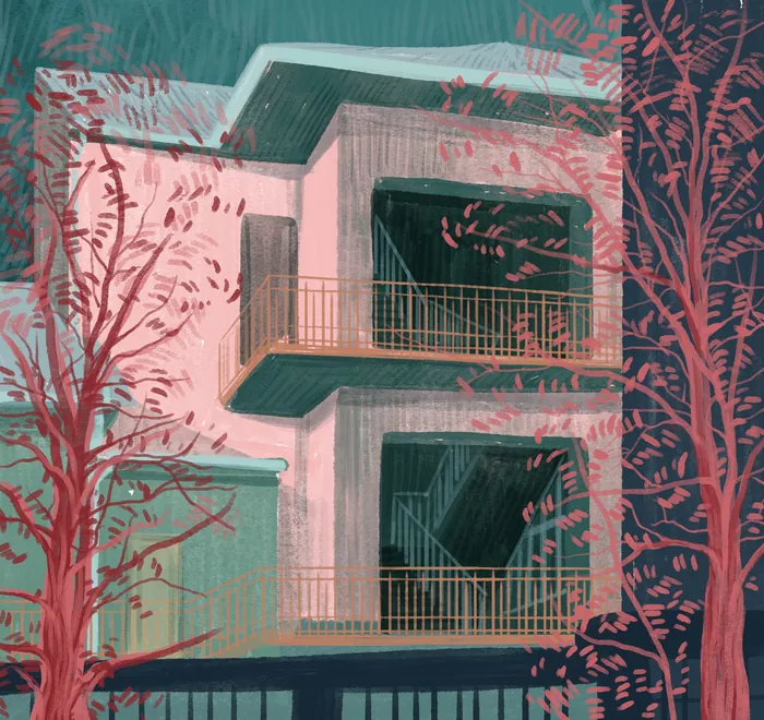 Modern building with balconies surrounded by bare red trees.