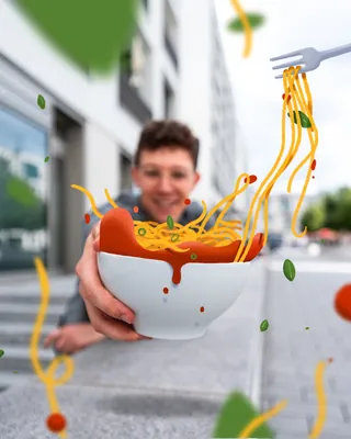 Man holding bowl of spaghetti with flying noodles and vegetables by Samy Löwe