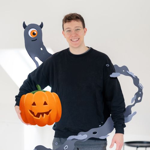 Person holding carved Halloween pumpkin with shadow art by Samy Löwe