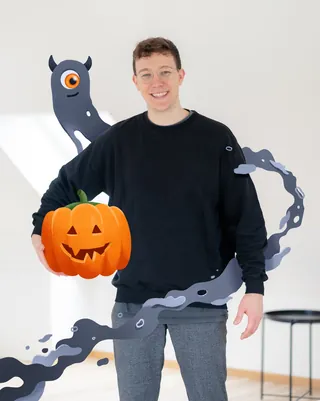 Person holding carved Halloween pumpkin with shadow art by Samy Löwe