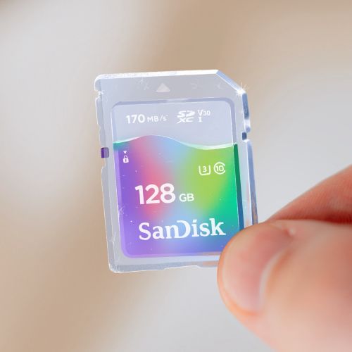 Hand holding SanDisk 128GB microSD memory card with multi-colored label