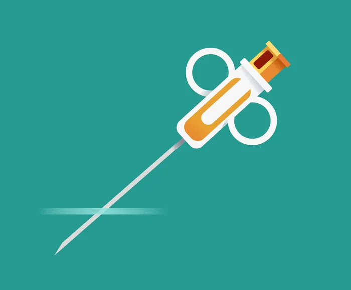 Syringe with orange liquid on teal background