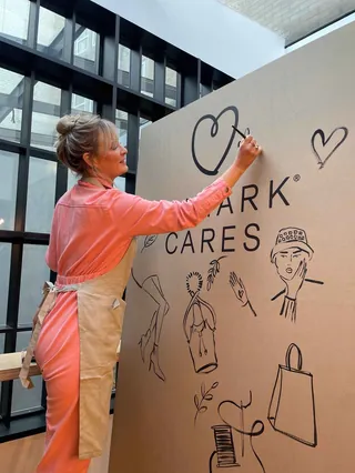Artist drawing fashion illustrations at brand PR event