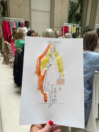 Hand holding a Hobbs fashion illustration at Somerset House event