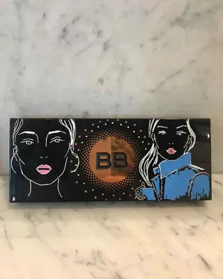 Bobbi Brown makeup palette with artistic face illustrations on marble