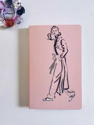 Illustration of a woman walking on a pink notebook cover