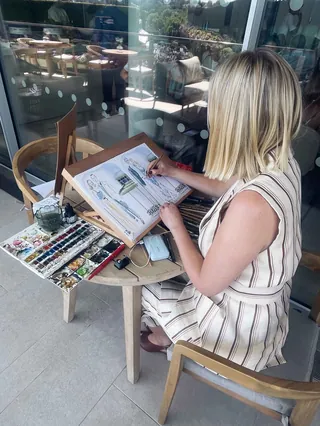 Artist doing live watercolor painting at outdoor lounge