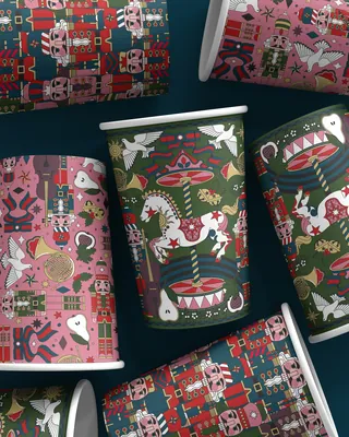 Christmas-themed coffee cups with nutcrackers, carousel horses, and doves