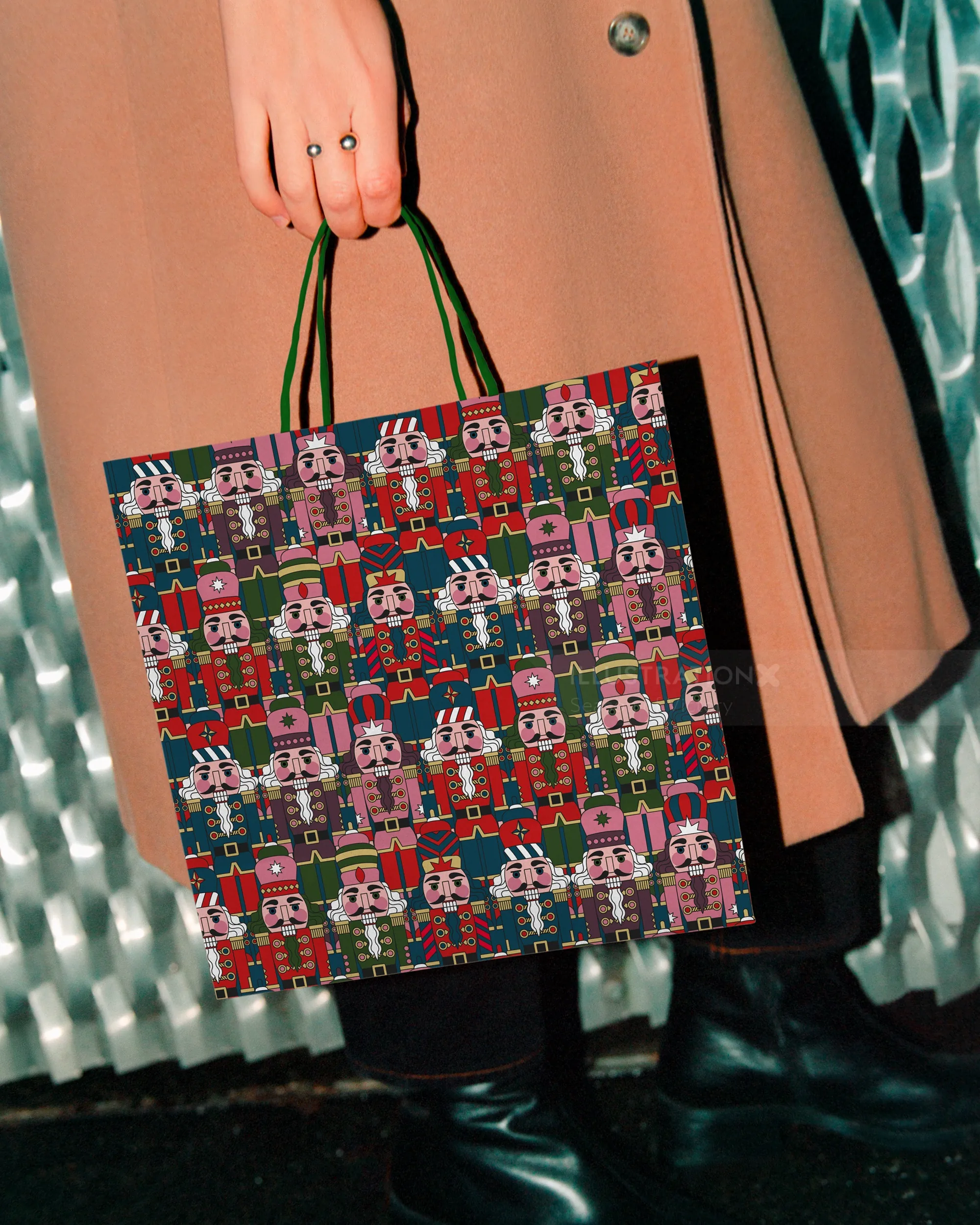 Hand holding a festive shopping bag with nutcracker pattern