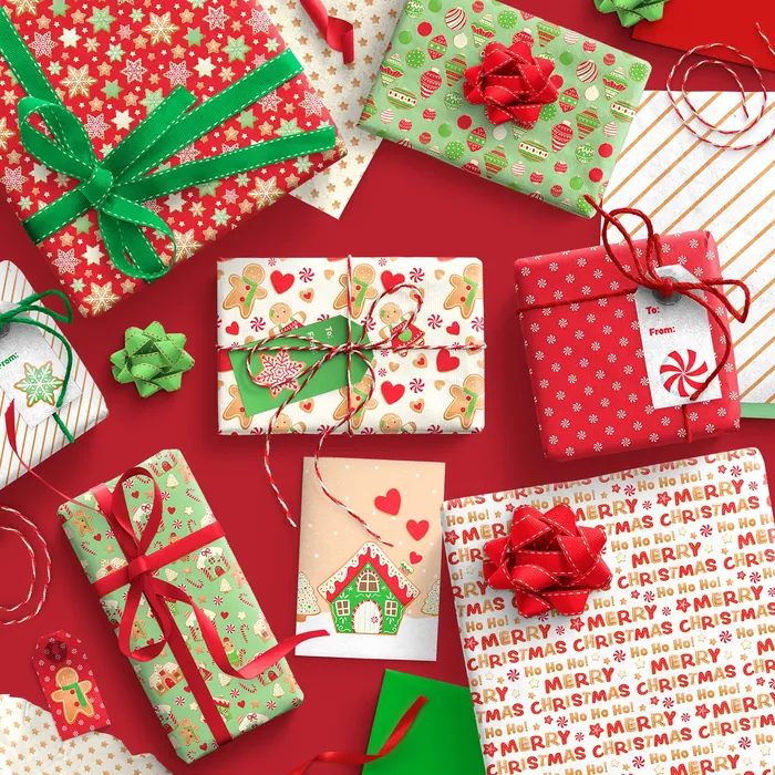 Christmas gifts wrapped in festive paper with bows on red background