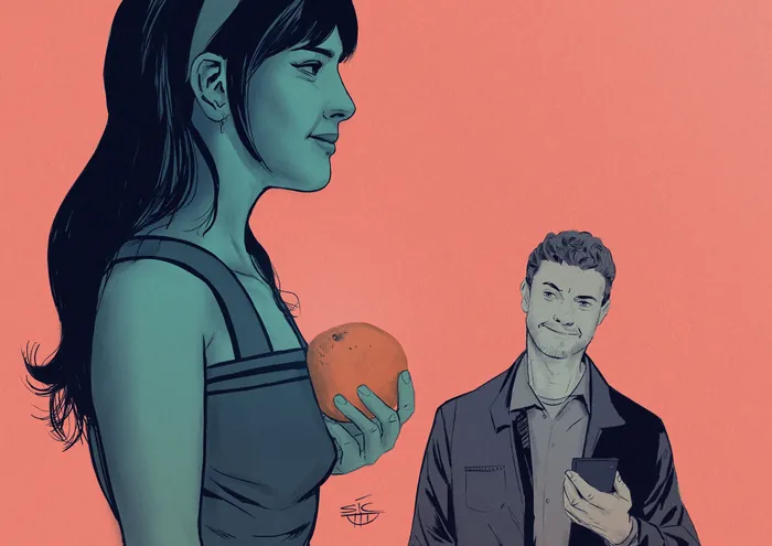 Woman holding an orange with a man smiling nearby