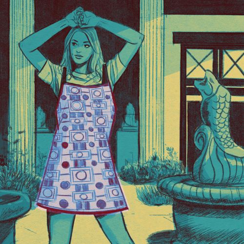 Woman wearing patterned smock in outdoor courtyard with fountain