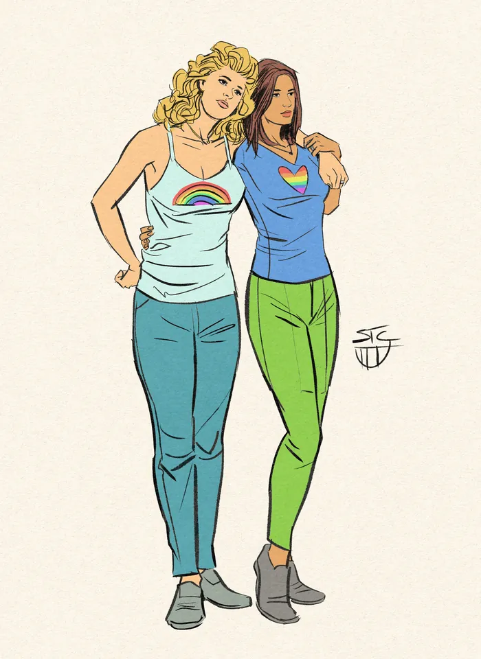 Two women embracing, wearing rainbow heart and rainbow shirts