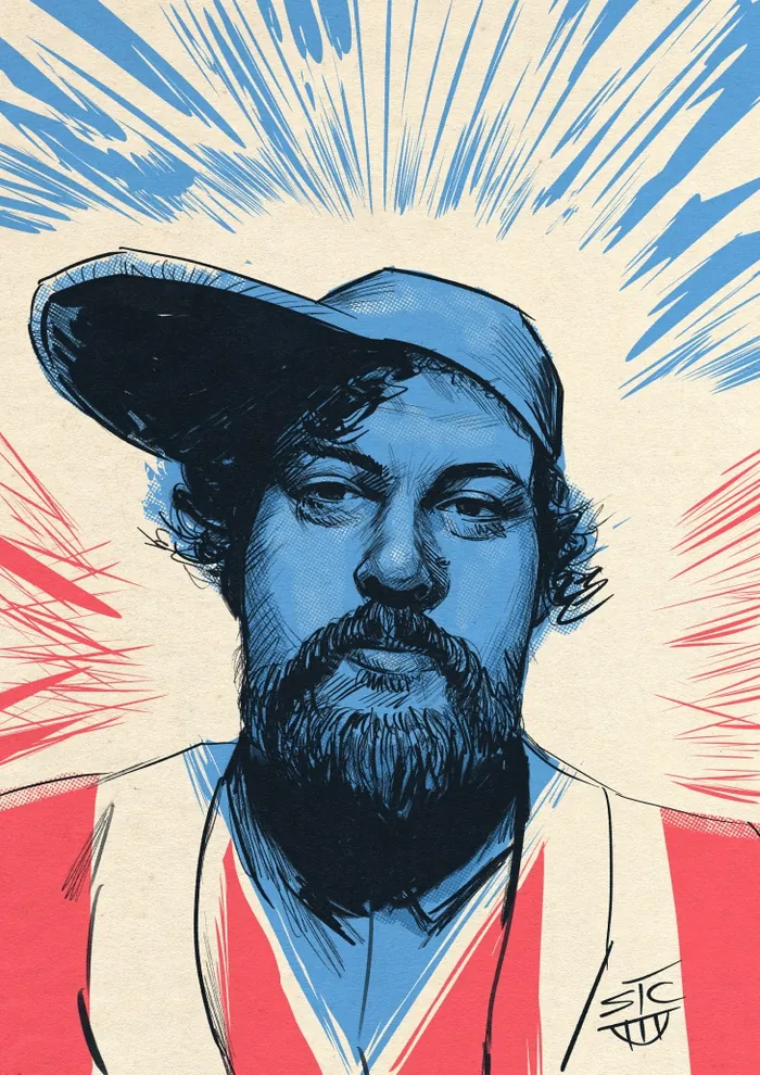 Blue-toned portrait of a bearded man in a cap with radiant background