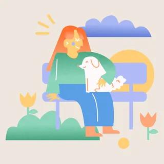 Person sitting on bench petting a happy dog outdoors