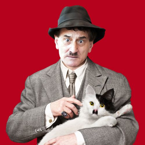 Man in gangster suit holding cat with black moustache