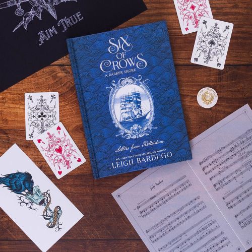 Studio Duco artwork featuring the Six of Crows book, playing cards, and etched illustrations