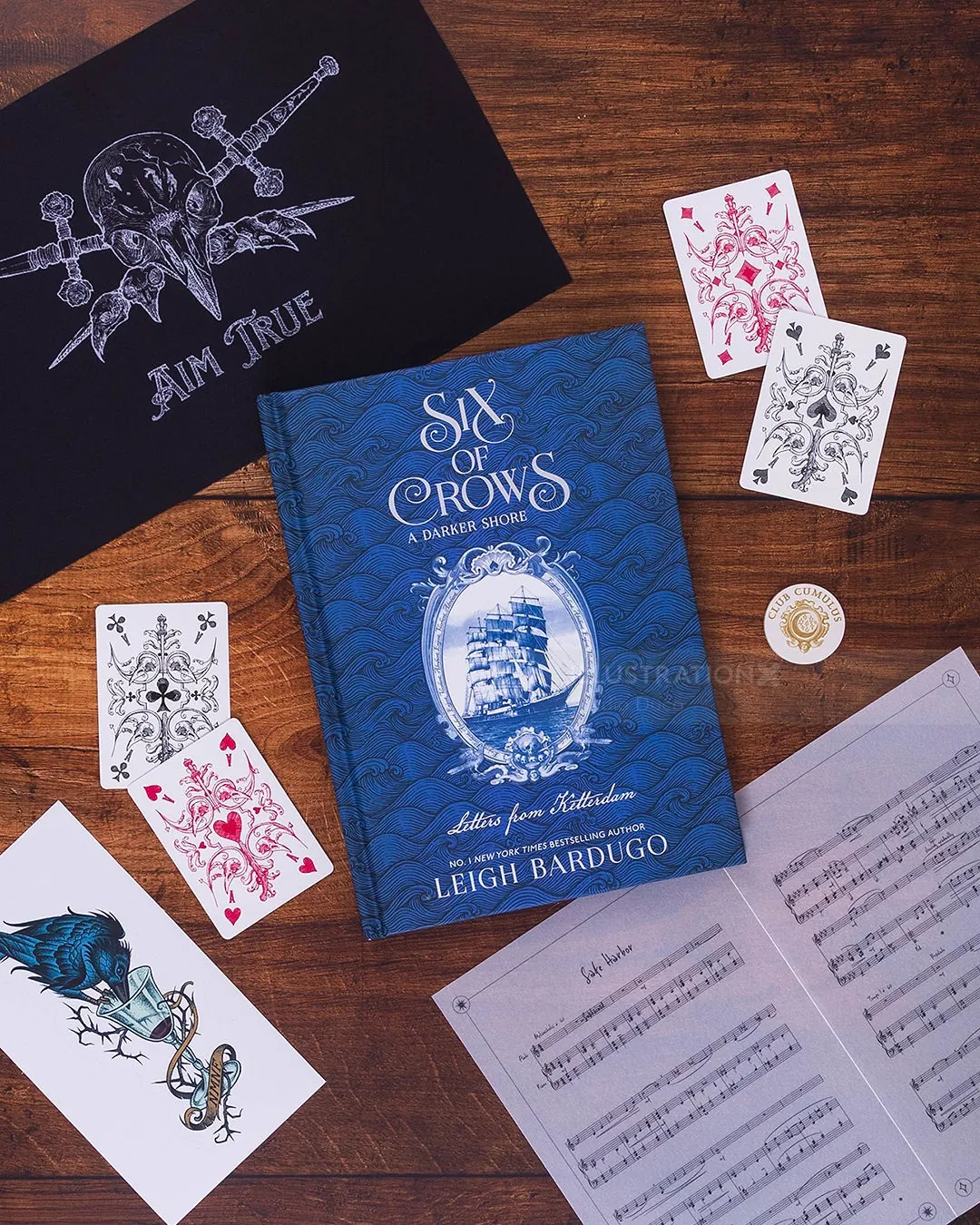 Studio Duco artwork featuring the Six of Crows book, playing cards, and etched illustrations