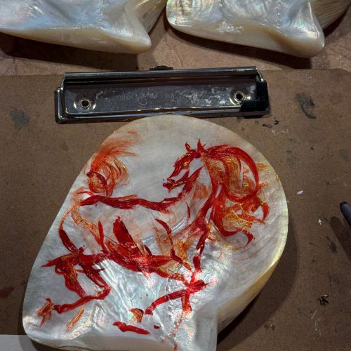 Hand-painted mother-of-pearl shells with red horse designs by Sunwoo Mansour