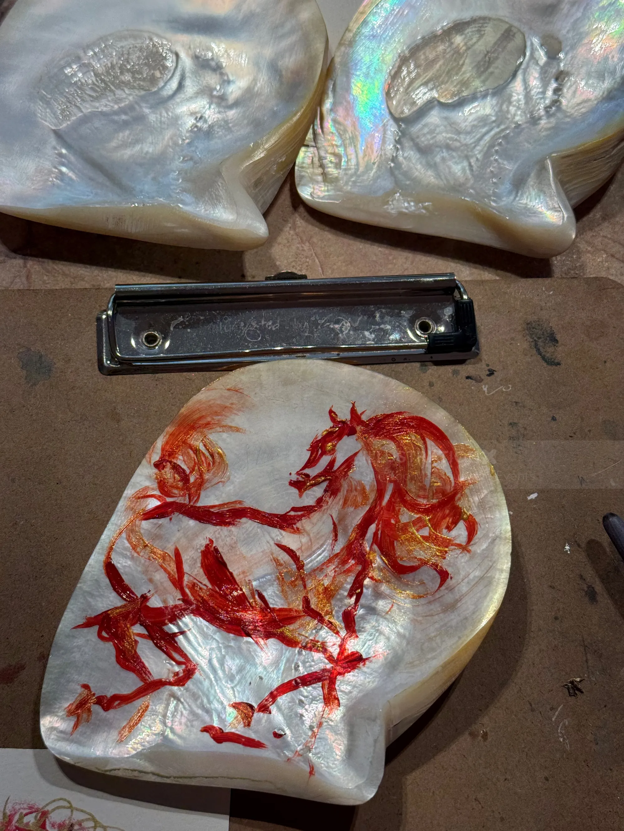 Hand-painted mother-of-pearl shells with red horse designs by Sunwoo Mansour