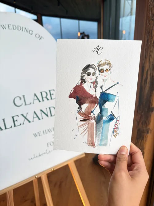 Hand holding a watercolor wedding invitation by Sunwoo Mansour Live Events