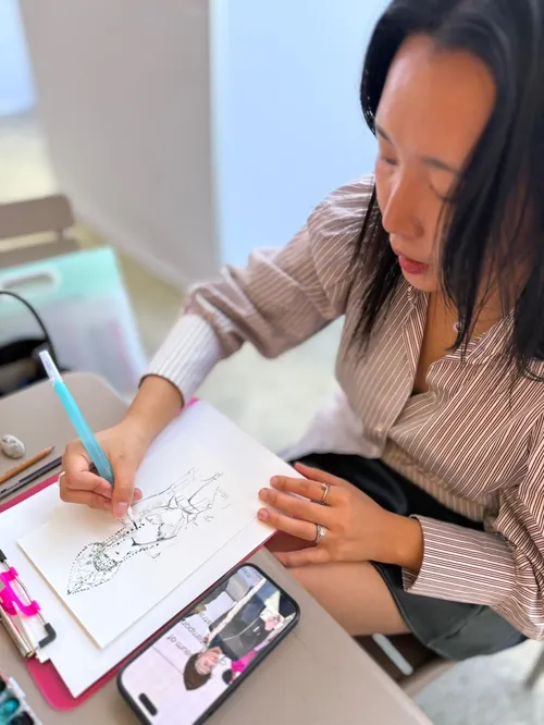 Woman sketching on paper at live event by Sunwoo Mansour Live Events