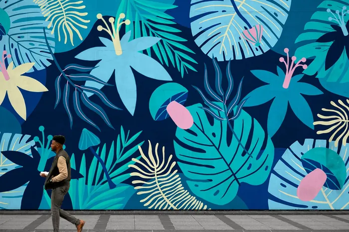 Person walks past bright floral mural by artist Superama