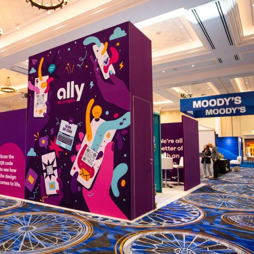 Ally booth with purple graphics and conference hall background