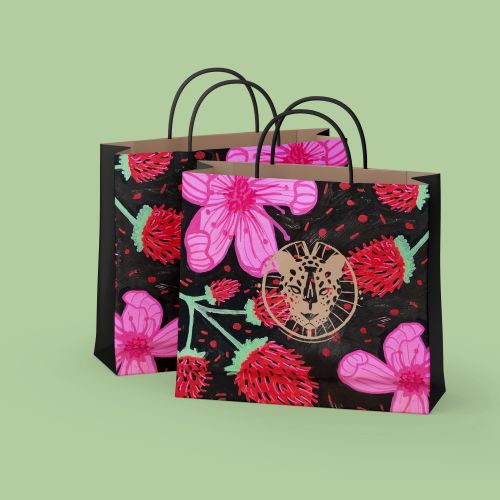 Black shopping bags with red and pink flower designs on green background